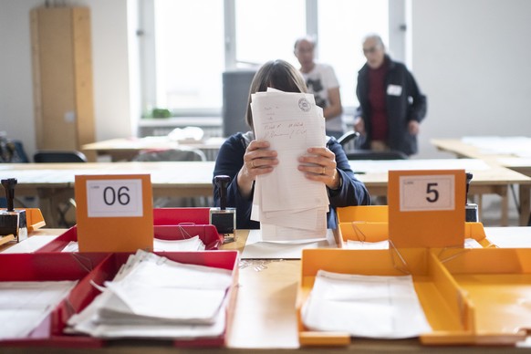 Eine Wahlhelferin in Zürich sortiert Wahlzettel. 