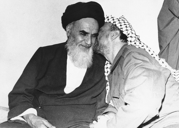 FILE - In this Feb. 18, 1979 file photo, Palestinian Liberation Organization leader Yasser Arafat, right, kisses Ayatollah Ruhollah Khomeini, left, during a meeting in Tehran, Iran. Forty years ago, I ...