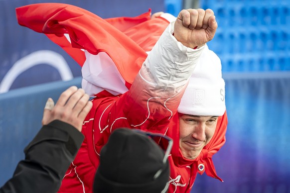 Gold medalist Franjo von Allmen of Switzerland, right, in the Superman pose next to Stefan Rogentin of Switzerland, left, after the men's alpine skiing Super-G race at the 2026 Olympic Winter Gam ...