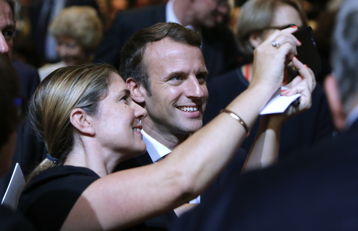 French President Emmanuel Macron takes a selfie with a woman as he opens the Frankfurt Book Fair in Frankfurt, Germany, Tuesday, Oct. 10, 2017. France is the partner country of this year's fair.  ...