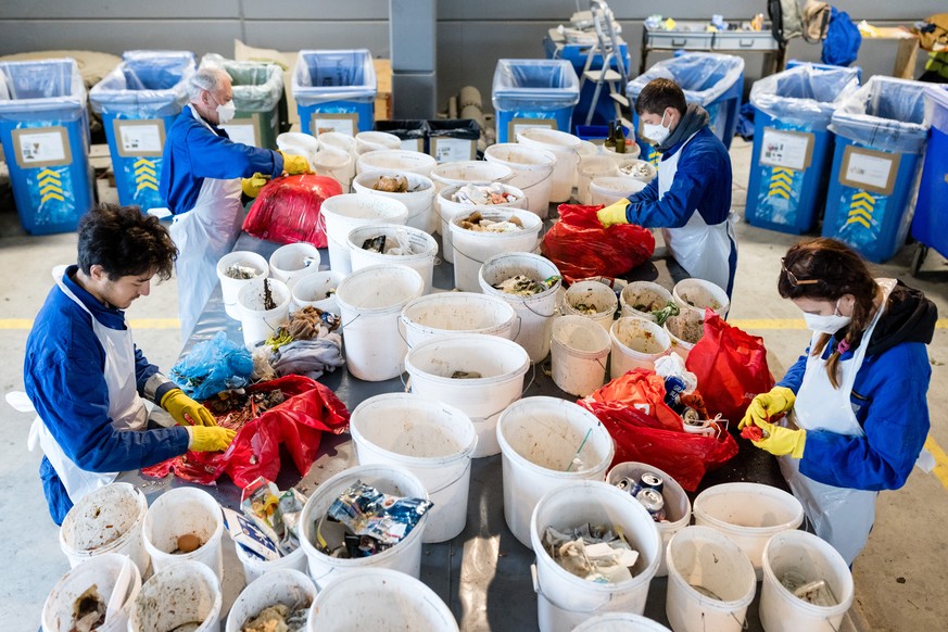 Several people are sorting waste on the occasion of a media event on waste analysis 2022 by the Federal Environment Agency FOEN on Tuesday, November 15, 2022 at the Perlen recycling center.  (KEYSTONE/Philipp Sch ...