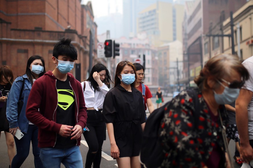 epa08058696 Pedestrians wear masks as smoke and haze from bushfires in New South Wales blankets the CBD in Sydney, Australia, 10 December 2019. The New South Wales environment department says visibili ...
