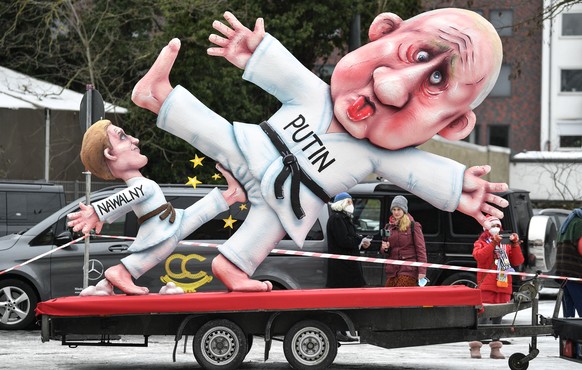 A political carnival float depicting Russia's President Vladimir Putin fighting with opposition Alexei Navalny is rolled out to be shown in the streets in Duesseldorf, Germany, Monday, Feb. 15, 2021.  ...