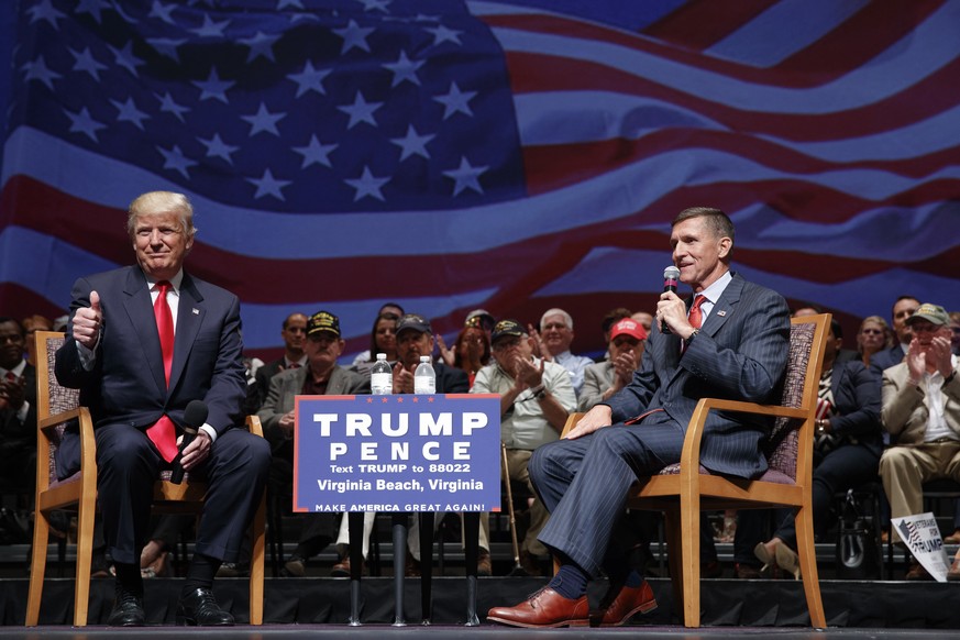 FILE - Then-presidential candidate Donald Trump gives a thumbs up as he speaks with retired Lt. Gen. Michael Flynn during a town hall, Tuesday, Sept. 6, 2016, in Virginia Beach, Va. President Donald T ...