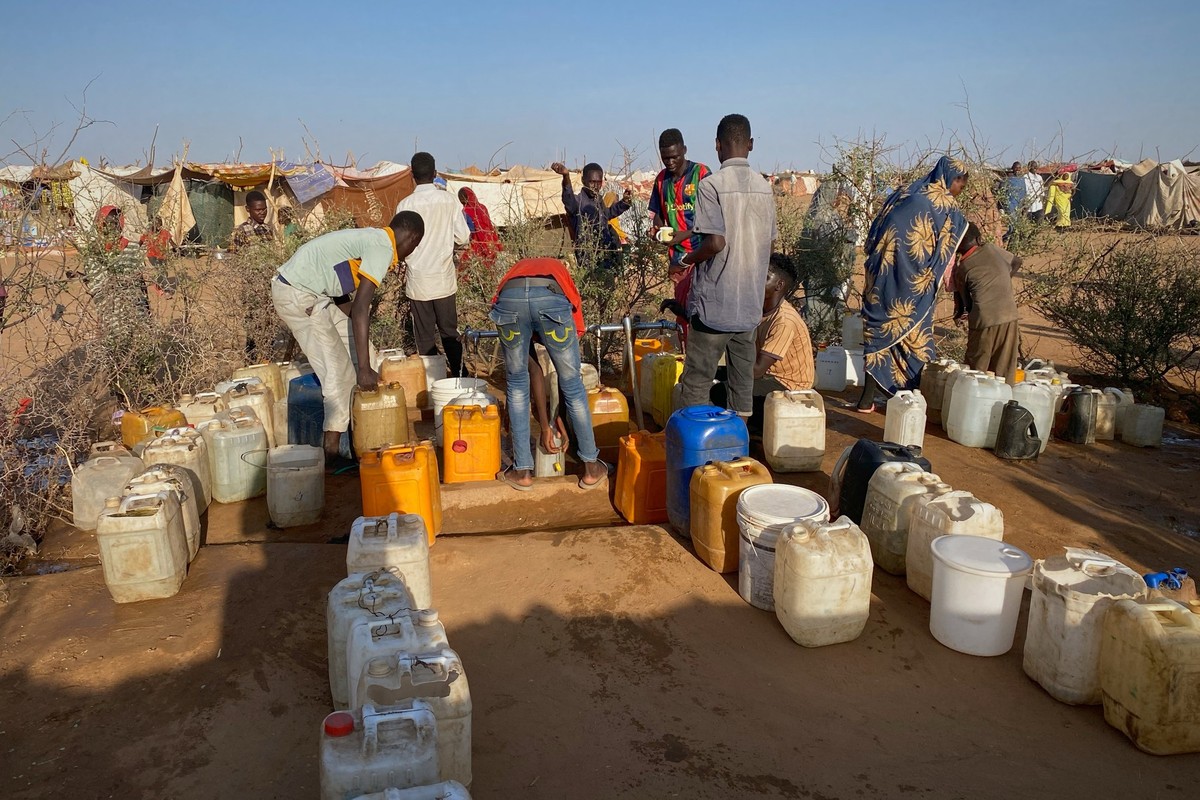 Sudanese men who fled el-Fasher city, after Sudan's paramilitary forces killed hundreds of people in the western Darfur region, collect water at a camp in Tawila, Sudan, Saturday, Nov. 1, 2025. ( ...