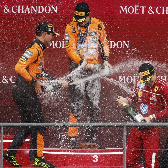 First place, McLaren driver Oscar Piastri of Australia, center, celebrates on the podium with second place McLaren driver Lando Norris of Britain, left, and third place Ferrari driver Charles Leclerc  ...
