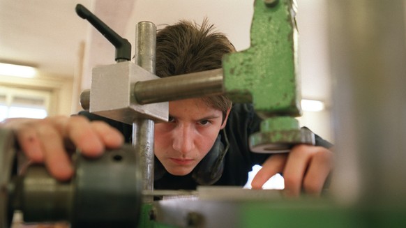 Ein Lehrling bei der Arbeit an der Maschine im Unterricht an der Abteilung Lehrwerkstaette fuer Moebelschreiner an der baugewerblichen Berufsschule Zuerich, aufgenommen am 4. Maerz 2003. (KEYSTONE/Gae ...