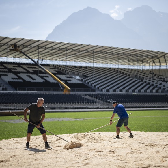 Helfer verteilen Saegemehl in der Arena des Eidgenoessischen Schwing- und Aelplerfestes 2025 Glarnerland+, am Montag, 18. August 2025, in Mollis. (KEYSTONE/Gian Ehrenzeller)