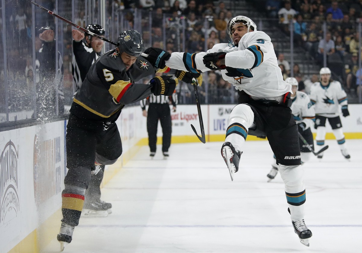 Vegas Golden Knights defenseman Deryk Engelland, left, checks San Jose Sharks left wing Evander Kane during the first period of an NHL preseason hockey game Sunday, Sept. 29, 2019, in Las Vegas. (AP P ...