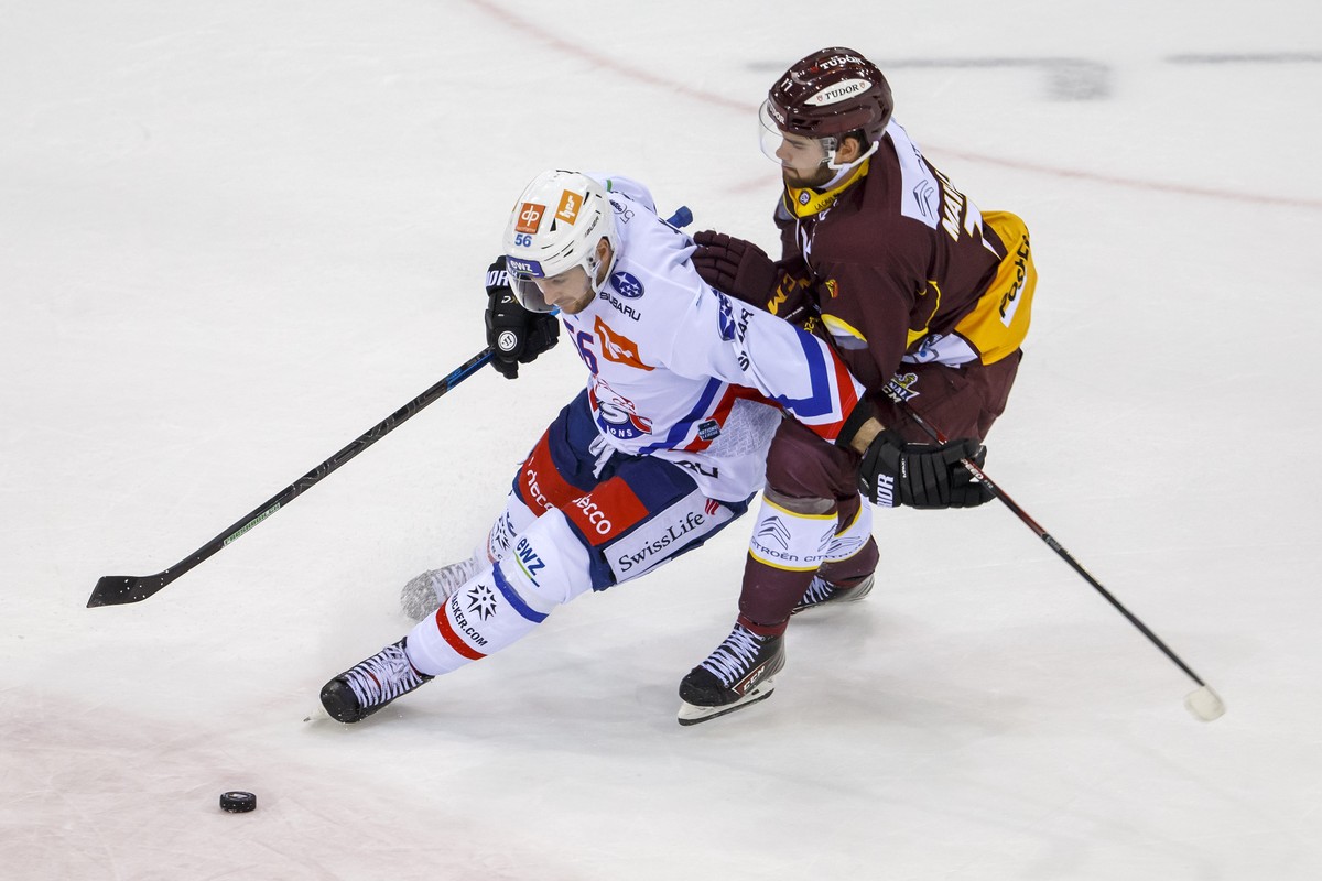 Lions' defender Maxim Noreau, of Canada, left, vies for the puck with Geneve-Servette's forward Guillaume Maillard, right, during a National League regular season game of the Swiss Champions ...