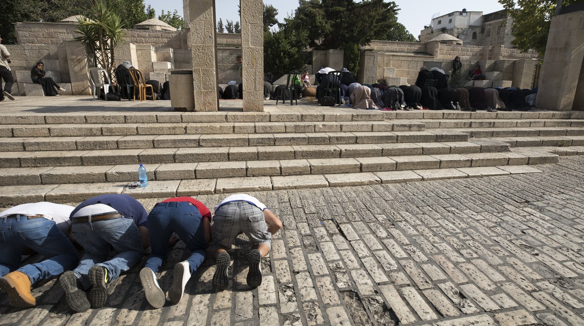 epa06107147 Palestinian men and women pray outside of the Lions' Gate, the main the entrance to the Al-Aqsa compound, in Jerusalem's old city, 24 July 2017. Jerusalem mufti Sheikh Mohammed H ...