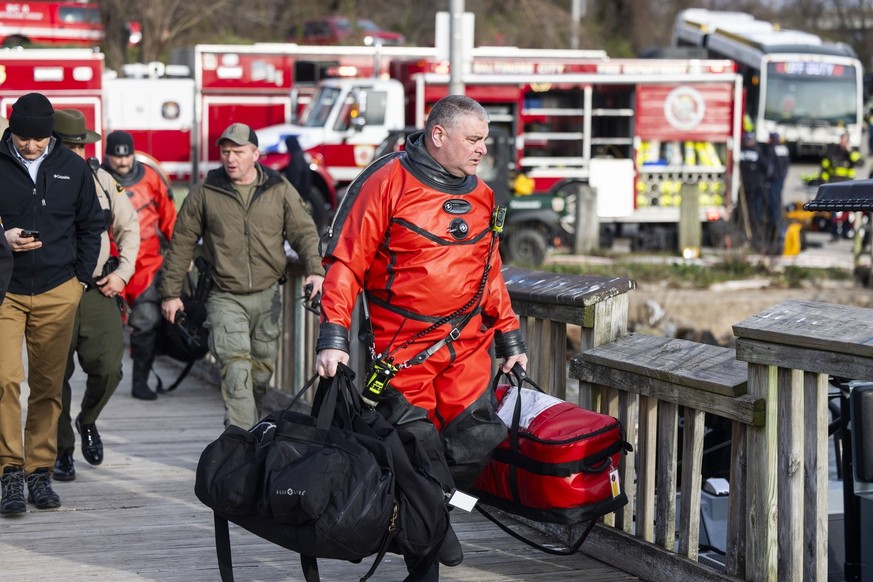epa11244502 Rescue personnel gather on the shore of the Patapsco River after a container ship ran into the Francis Scott Key Bridge causing its collapse in Baltimore, Maryland, USA, 26 March 2024. The ...