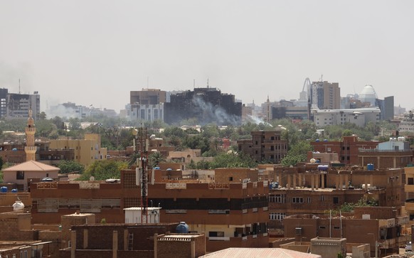 epa10578771 A civilian holds up an empty shell casing in front of a damaged window of a residential building during ongoing clashes between the Sudanese army and Rapid Support Forces paramilitaries...