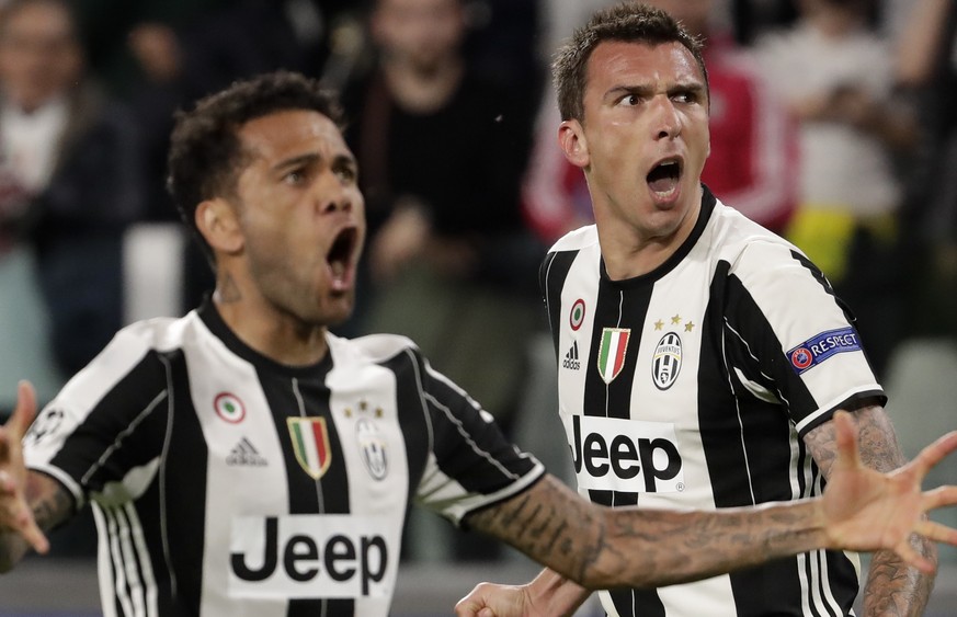 Juventus&#039; Mario Mandzukic, right, celebrates after scoring his side&#039;s opening goal besides team mate Dani Alves during the Champions League semi final second leg soccer match between Juventu ...