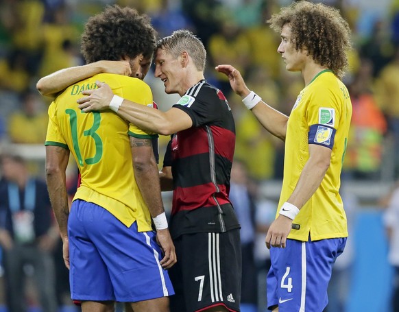 epa04306464 Brazil's Dante (L-R), Germany's Thomas Mueller, Germany's Bastian Schweinsteiger and Brazil's David Luiz (R) hug after Germany won the FIFA World Cup 2014 semi final ma ...