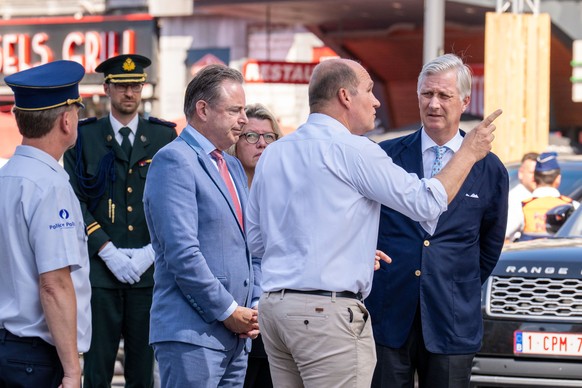 Belgium's King Philippe, right, and Belgium's Prime Minister Bart De Wever, center, speak with Brussels Mayor Philippe Close, second right, as the visit the scene of a fire at a building com ...