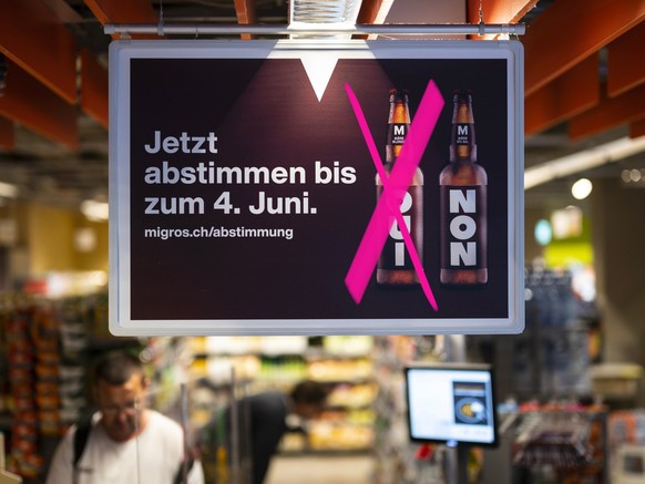 Plakate weisen auf die Abstimmung zum moeglichen Verkauf von alkoholischen Getraenken in der Migros hin, am Dienstag, 24. Mai 2022 in der Migros Filiale Lorraine in Bern. Anfang Juni 2022 koennen die  ...