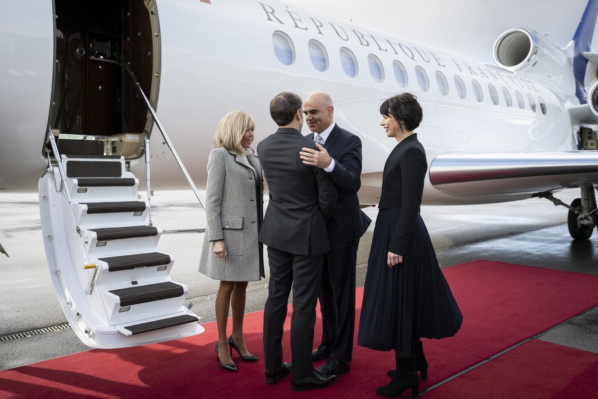 Switzerland President Alain Berset, center-right, and his wife Muriel Zeender Berset, right, welcome French President Emmanuel Macron, center-left, and his wife Brigitte Macron, left, at the Bern-Belp ...