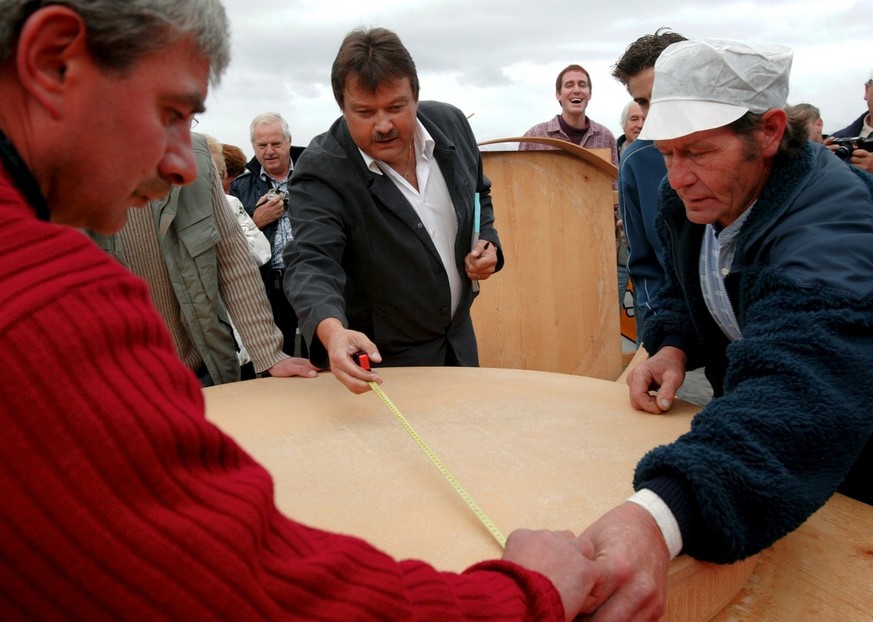 Au centre, le conseille national et notaire Maurice Chevrier a pris acte du record battu du plus grand fromage a raclette rond avec 135 kg et un diametre de 123 cm a l&#039;alpage de Nax ce dimanche 2 ...