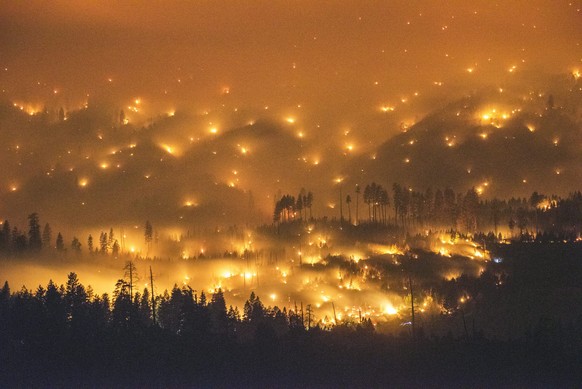 epa04333910 A long exposure image shows the El Portal Fire burning near Yosemite National Park, California, USA, late 27 July 2014. On the morning of 28 July, the fire had burned over 2,500 acres (1,011 hectares) and was just 5% contained. More than 400 firefighters and several helicopters are battling the flames near Yosemite. EPA/STUART PALLEY