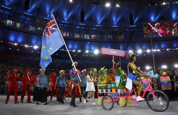 2016 Rio Olympics - Opening ceremony - Maracana - Rio de Janeiro, Brazil - 05/08/2016. Flagbearer Etimoni Timuani (TUV) of Tuvalu leads his country&#039;s contingent into the stadium. REUTERS/Kai Pfaf ...