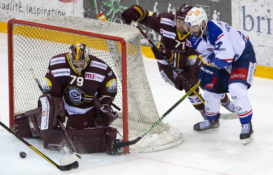 Geneve-Servette&#039;s goaltender Daniel Manzato, left, saves a puck past Geneve-Servette&#039;s center Tanner Richard, 2n right and Lions&#039; forward Denis Hollenstein, right, during the second leg ...