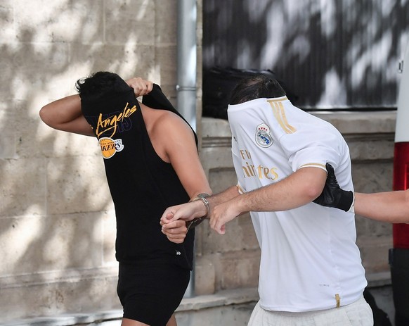 epa10747422 Spanish policemen escort six German tourists arrested for allegedly sexually assaulting a German young woman upon arrival to the courts of Palma de Mallorca, Mallorca Island, Balearics, Sp ...