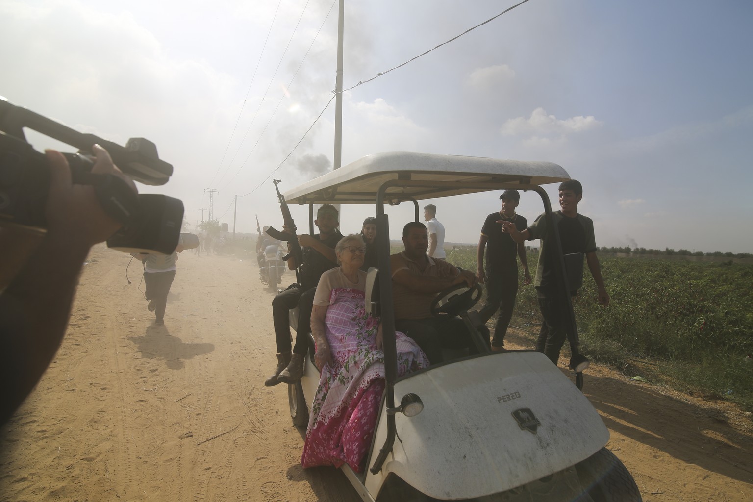 Palestinians transport a captured Israeli civilian from Kfar Azza kibbutz into the Gaza Strip on Saturday, Oct. 7, 2023. The militant Hamas rulers of the Gaza Strip carried out an unprecedented, multi ...