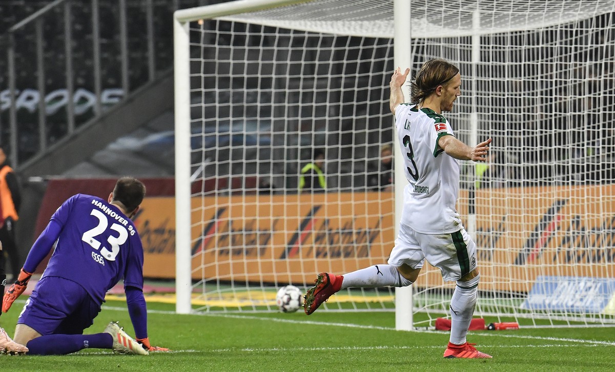 Moenchengladbach's Michael Lang scores his side's second goal against Hannover goalkeeper Michael Esser during the German Bundesliga soccer match between Borussia Moenchengladbach and Hannov ...