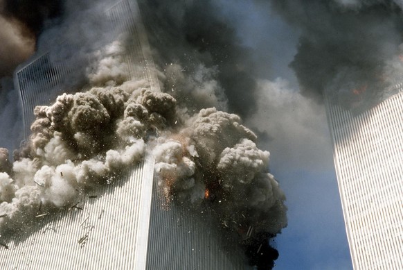 La tour sud du World Trade Center, à gauche, commence à s'effondrer après une attaque terroriste contre les bâtiments emblématiques à New York, aux États-Unis, le mardi 11 septembre 2001.
