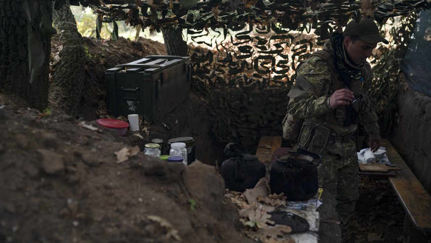 A Ukrainian serviceman checks the trenches dug by Russian soldiers in a retaken area in Kherson region, Ukraine, Wednesday, Oct. 12, 2022. (AP Photo/Leo Correa)