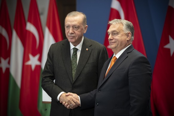 epa11036210 A handout photo provided by the Hungarian Prime Minister's Office shows Hungarian Prime Minister Viktor Orban (R) and Turkish President Recep Tayyip Erdogan (L) shaking hands after ...