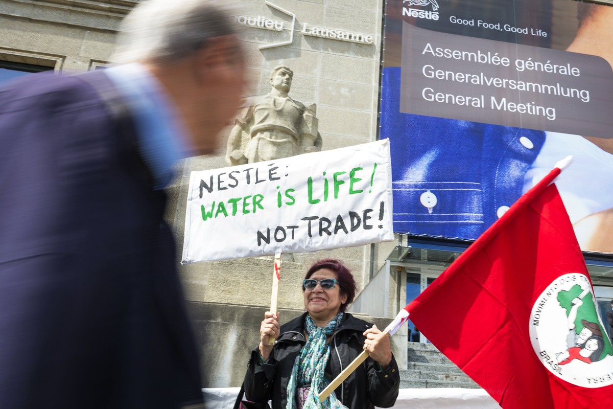 epa06664118 Members of 'Multiwatch' association protest outside the general meeting of the world's biggest food and beverage company, Nestle Group, in Lausanne, Switzerland, 12 April 20 ...