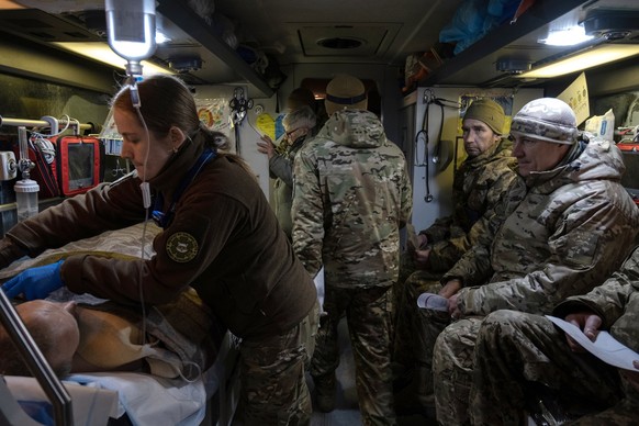 epa11764318 Sofia, a Hospitallers volunteer paramedic, treats a wounded Ukrainian soldier during an evacuation in a medical bus to a hospital, in the Donetsk region, Ukraine, 06 December 2024 (issued  ...