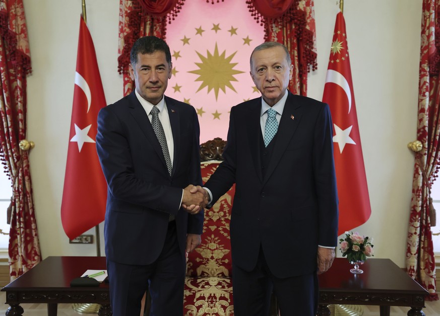 In this photo released by Turkish Presidency, Turkish President and People&#039;s Alliance&#039;s presidential candidate Recep Tayyip Erdogan, right, shakes hands with Sinan Ogan, former presidential  ...