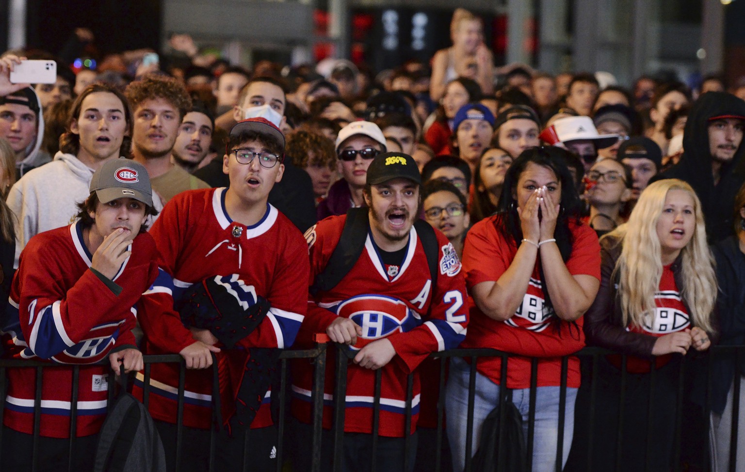 Montreal Canadiens fans react while watching coverage of Game 5 of the NHL hockey Stanley Cup Finals between the Canadiens and the Tampa Bay Lightning, outside the Bell Centre in Montreal on Wednesday ...