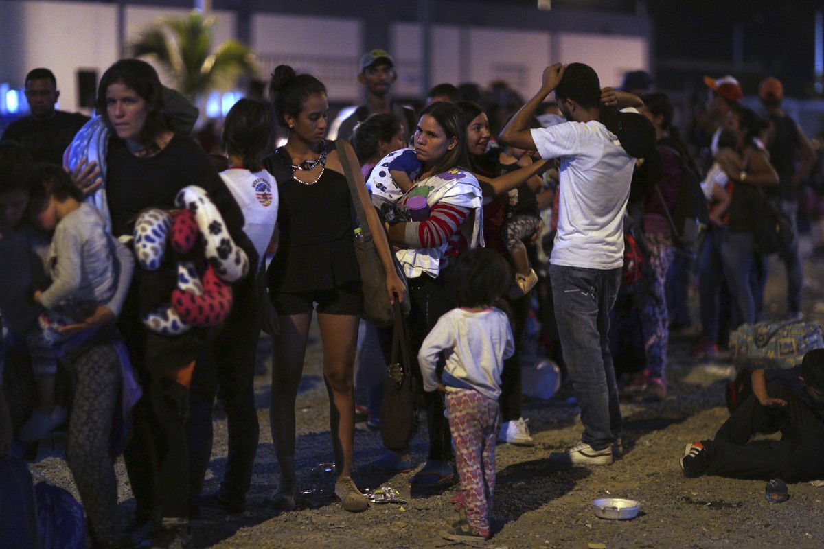 Venezuelans wait to pass immigration control at the Ecuador-Peru border, before the deadline on stricter regulations that require passports, in Tumbes, Peru, Friday, June 14, 2019. While Venezuela is  ...