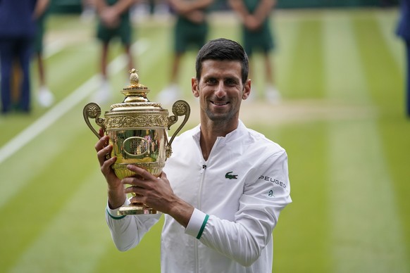 FILE - In this July 11, 2021, file photo, Serbia&#039;s Novak Djokovic holds the trophy after his win over Italy&#039;s Matteo Berrettini in the men&#039;s singles final match of the Wimbledon Tennis  ...