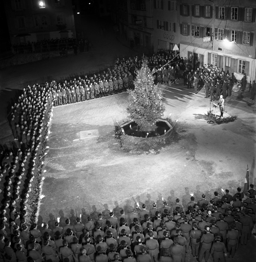 General Henri Guisan feiert bei der im Felde stehende Truppe auf dem Dorfplatz von Wassen, Schweiz, am 24. Dezember 1943 Weihnachten. Der General spricht vor der versammelten Einheit und dem geschmuec ...