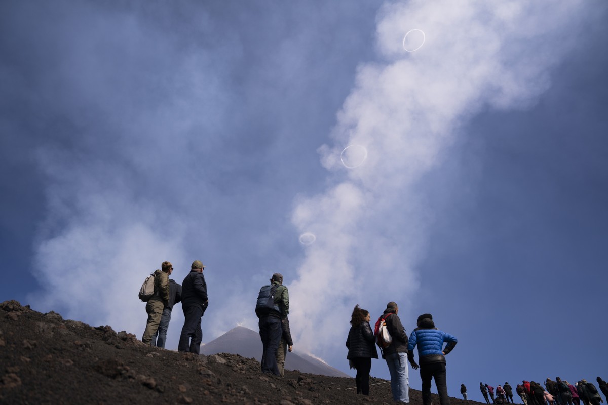 People look at volcanic vortex rings emerging from a new pit crater on the north side of the southeast crater of the Etna Volcano in Sicily, Italy, Friday, April 5, 2024. While the physical conditions ...