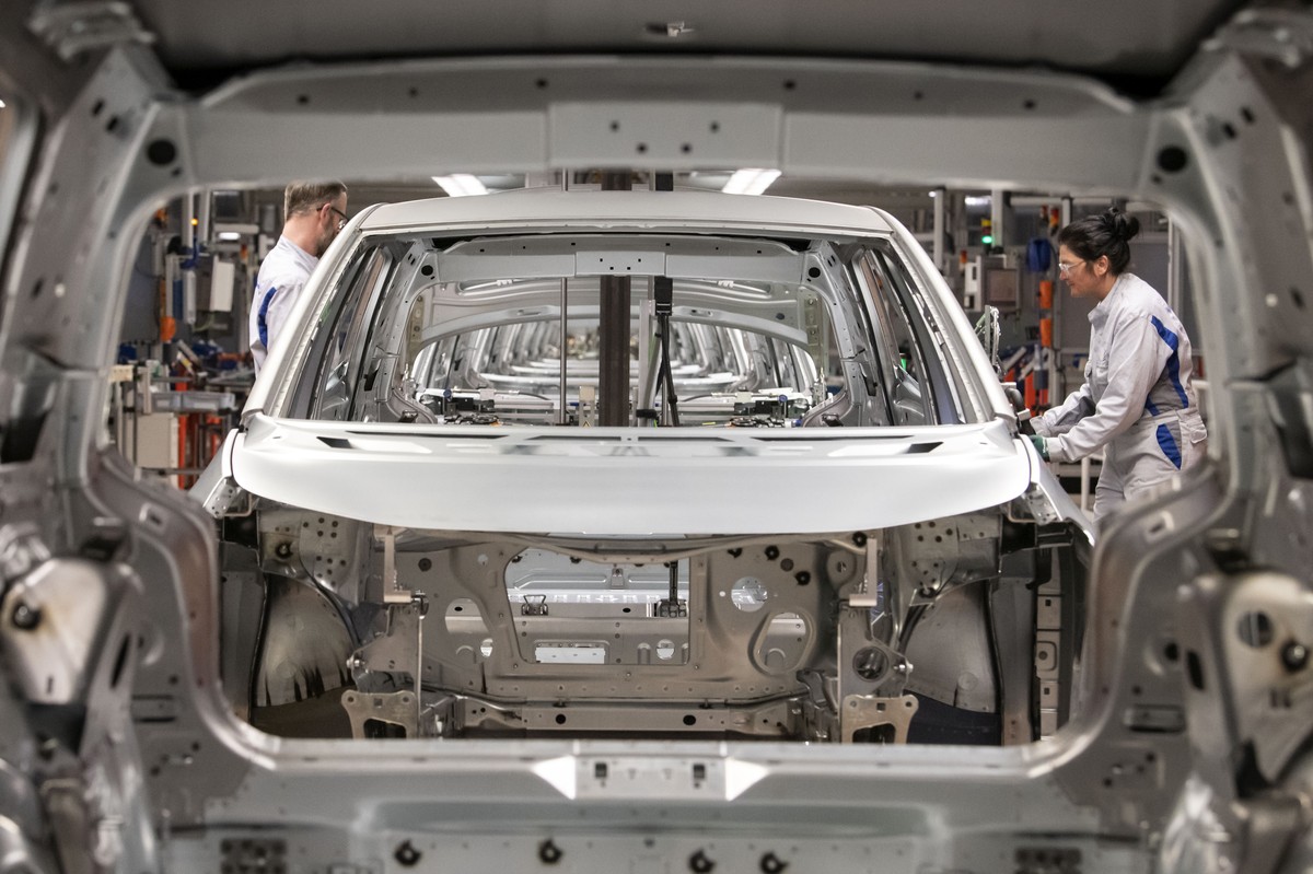 FILE - In this Tuesday, Feb. 25, 2020 file photo, workers complete an electric car ID.3 body at the assembly line during a press tour at the plant of the German manufacturer Volkswagen AG (VW) in Zwic ...