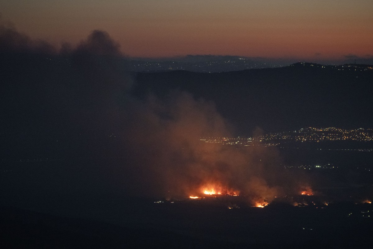 Smokes rises from a fire after a strike from Lebanon on an area next to the kibbutz HaGoshrim, located near the israeli-Lebanese border, seen from the village of Mas'ade in the Israeli-annexed Go ...
