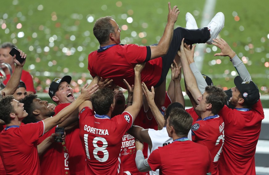 Bayern&#039;s head coach Hans-Dieter Flick is tossed in the air by his players as they celebrate after winning the Champions League final soccer match between Paris Saint-Germain and Bayern Munich at  ...