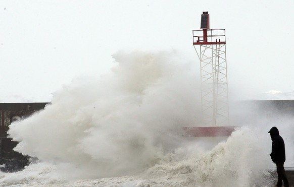 A person watches the sea in Anglet, southwestern France, Sunday, Nov.3, 2019. Most of the French regions are on alert for violent storms and high winds. (AP Photo/Bob Edme)