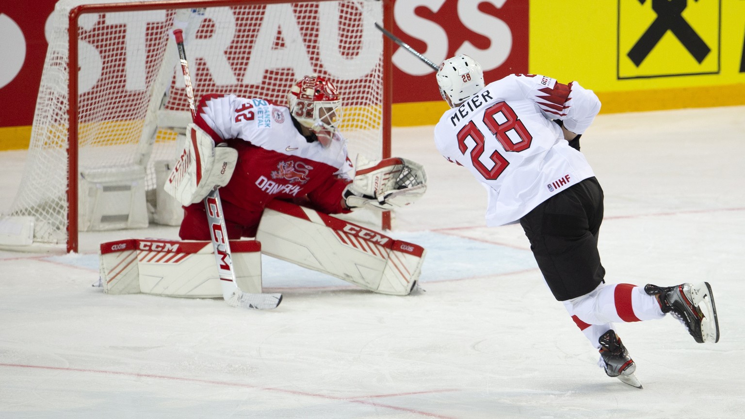 epa09223720 Denmark&#039;s goaltender Sebastian Dahm (L) blocks a puck shooting from Switzerland&#039;s forward Timo Meier during the IIHF 2021 World Championship Group A match between Denmark and Swi ...