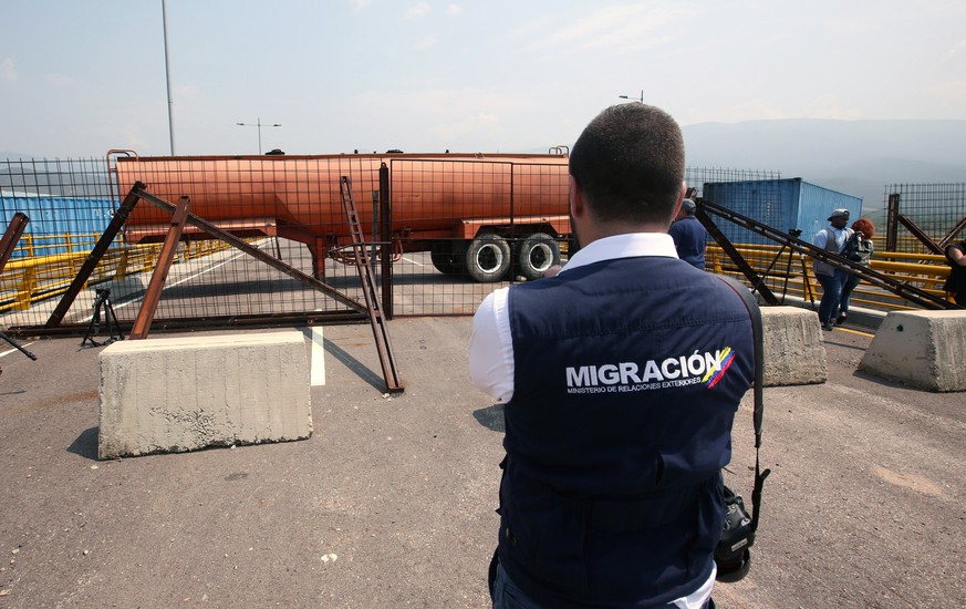 epa07348319 A Colombian Customs agent observes the blockade of the border bridge of Tienditas between Colombia and Venezuela, in Cucuta, Colombia, 06 February 2019, where Venezuela&#039;s National Bol ...