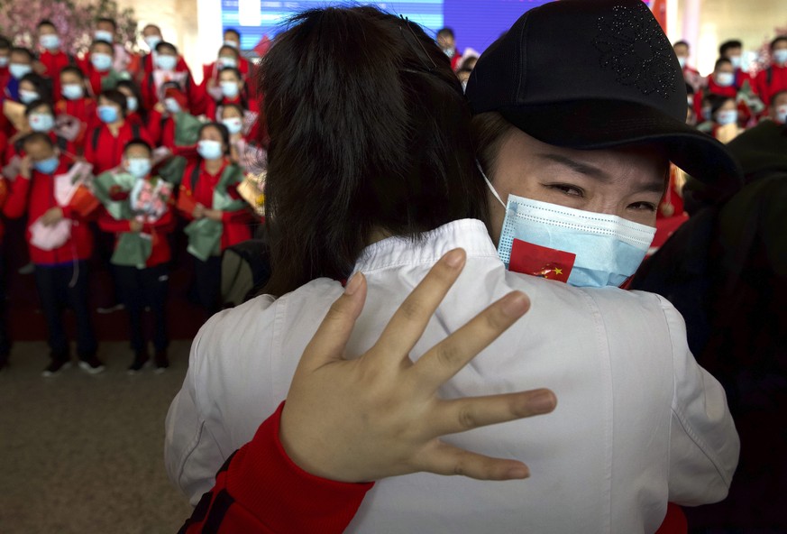 A medical worker from China's Jilin Province reacts as she prepares to return home at Wuhan Tianhe International Airport in Wuhan in central China's Hubei Province, Wednesday, April 8, 2020. Within ho ...