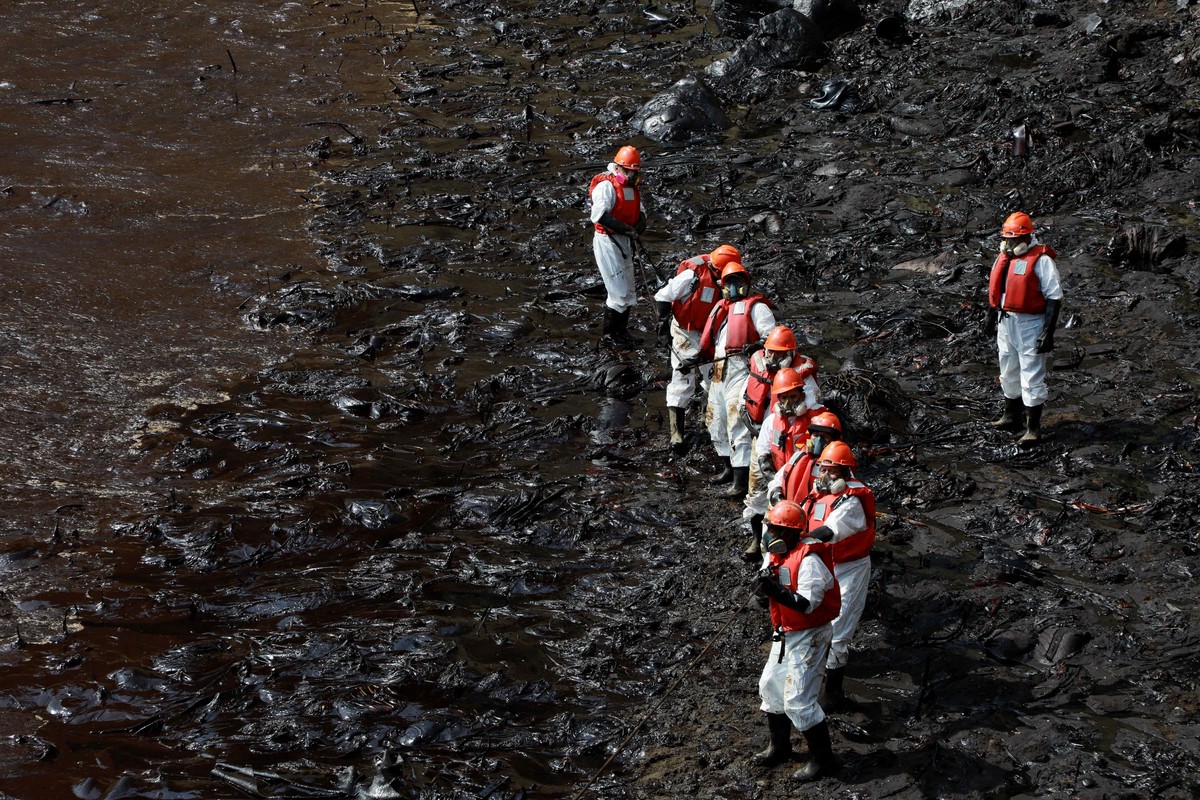 epaselect epa09709349 Workers carry out a cleaning operation on the beaches of Ventanilla, Peru, 25 January 2022. The Repsol company stated that it is 'closely collaborating' with civil soci ...