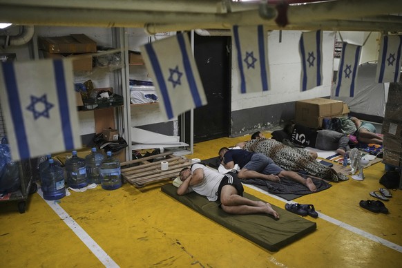 People rest and as they take shelter in an underground parking garage as a precaution against possible Iranian missile attacks, in Tel Aviv, Israel, Tuesday, June 24, 2025. (AP Photo/Ohad Zwigenberg)
 ...