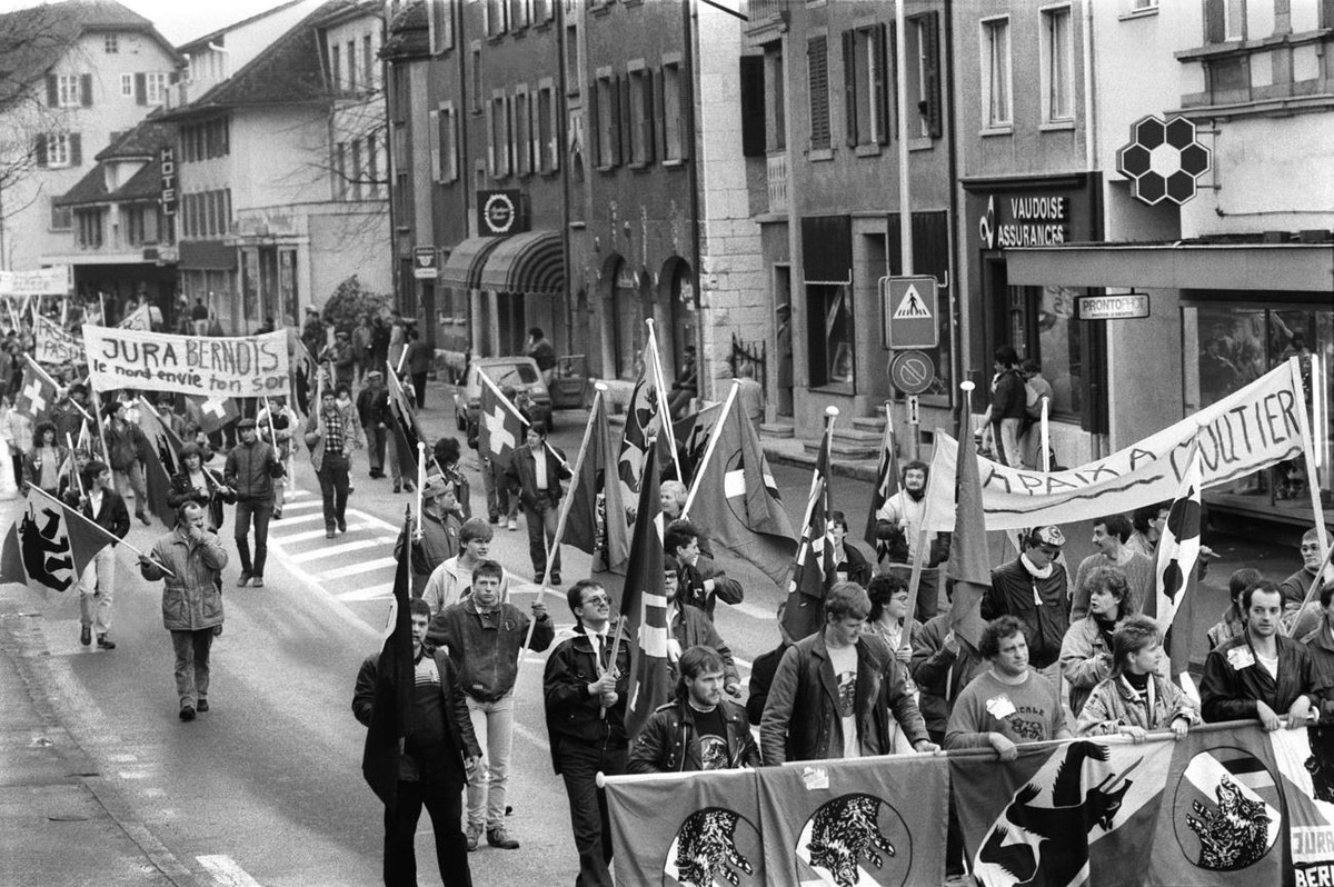 Die probernischen Sangliers marschieren mit Fahnen, Parolen skandierend, durch die Strassen von Moutier, aufgenommen am 19. Maerz 1988. (KEYSTONE/STR)